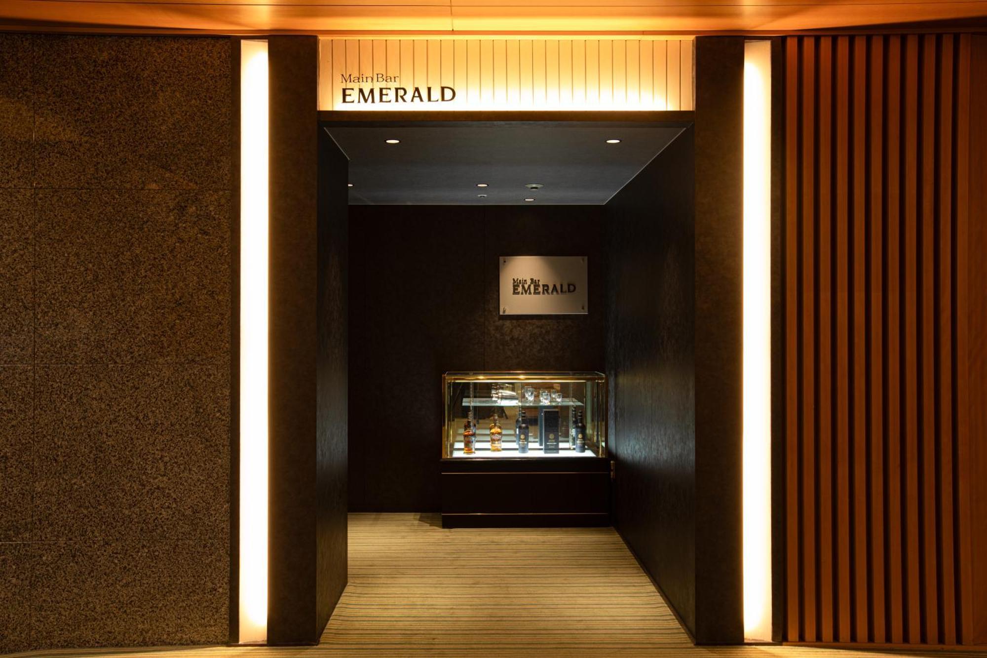 Hotel Okura Kōbe Exterior foto The photo depicts the entrance to a store or boutique called "EMERALD." The entrance features a sleek, modern design with dark walls and warm lighting. A display case can be seen inside, suggesting the store may sell jewelry or luxury items. The over
